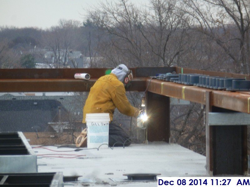 Welding metal clips along the low roof facing North